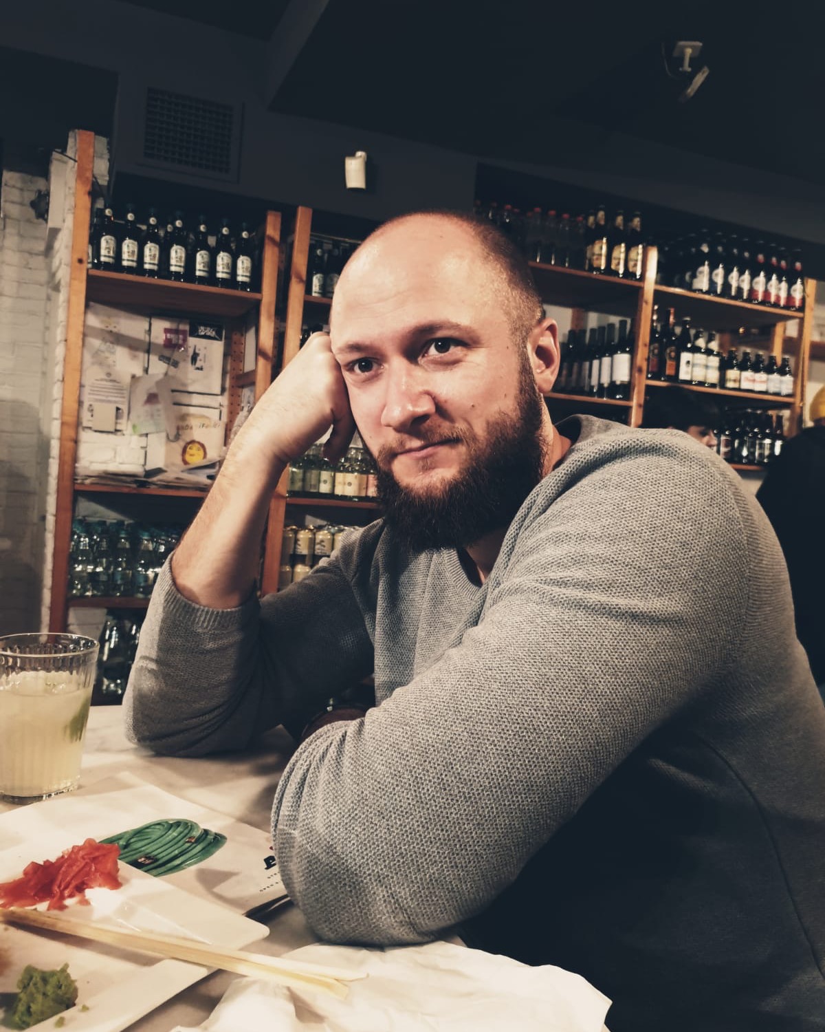Cristian Tăbăcitu, sitting at a wine bar, looking at the camera